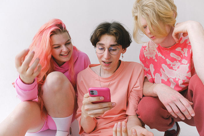 three teens looking at phone 