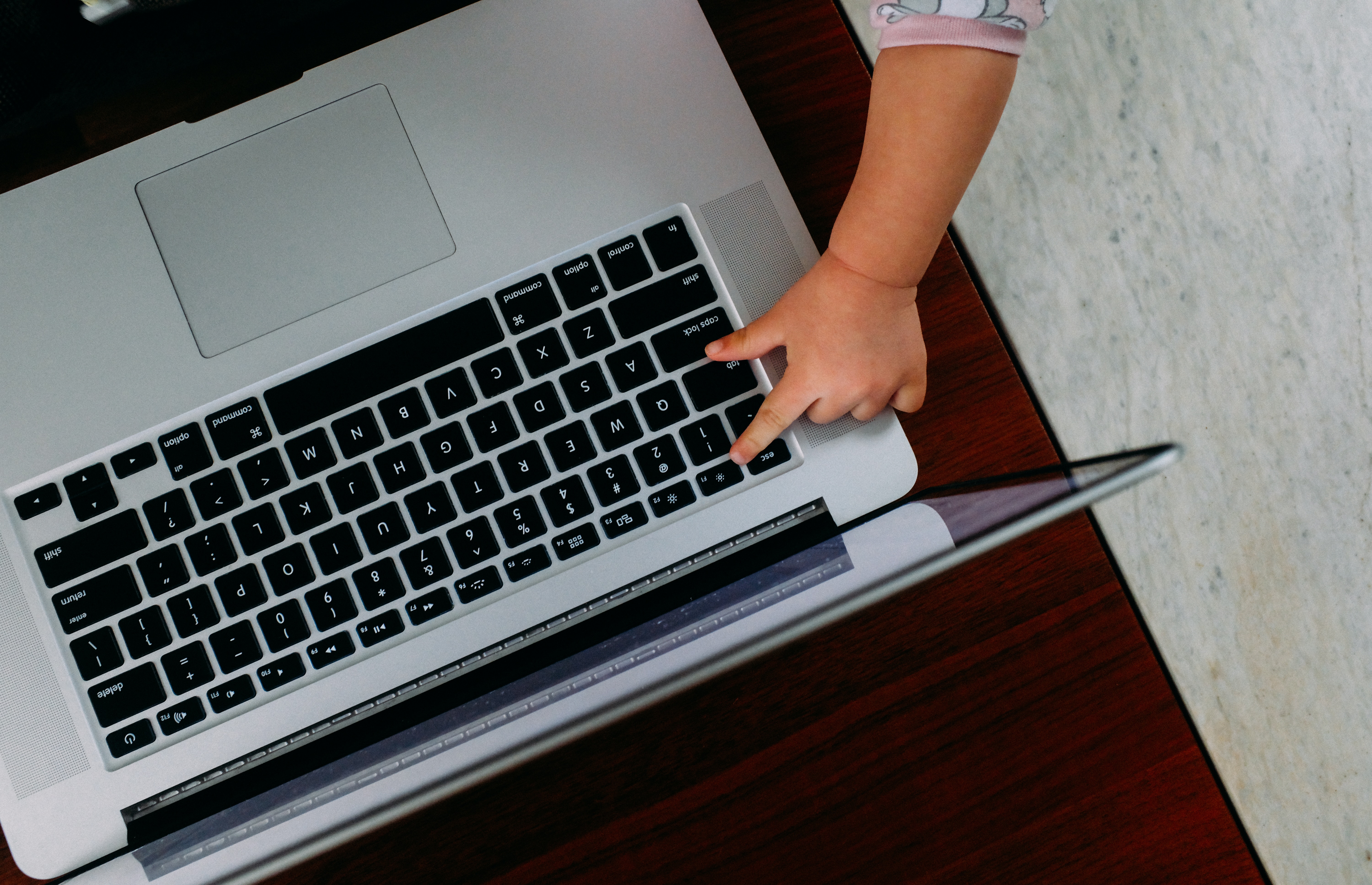 child pressing the esc button on laptop 