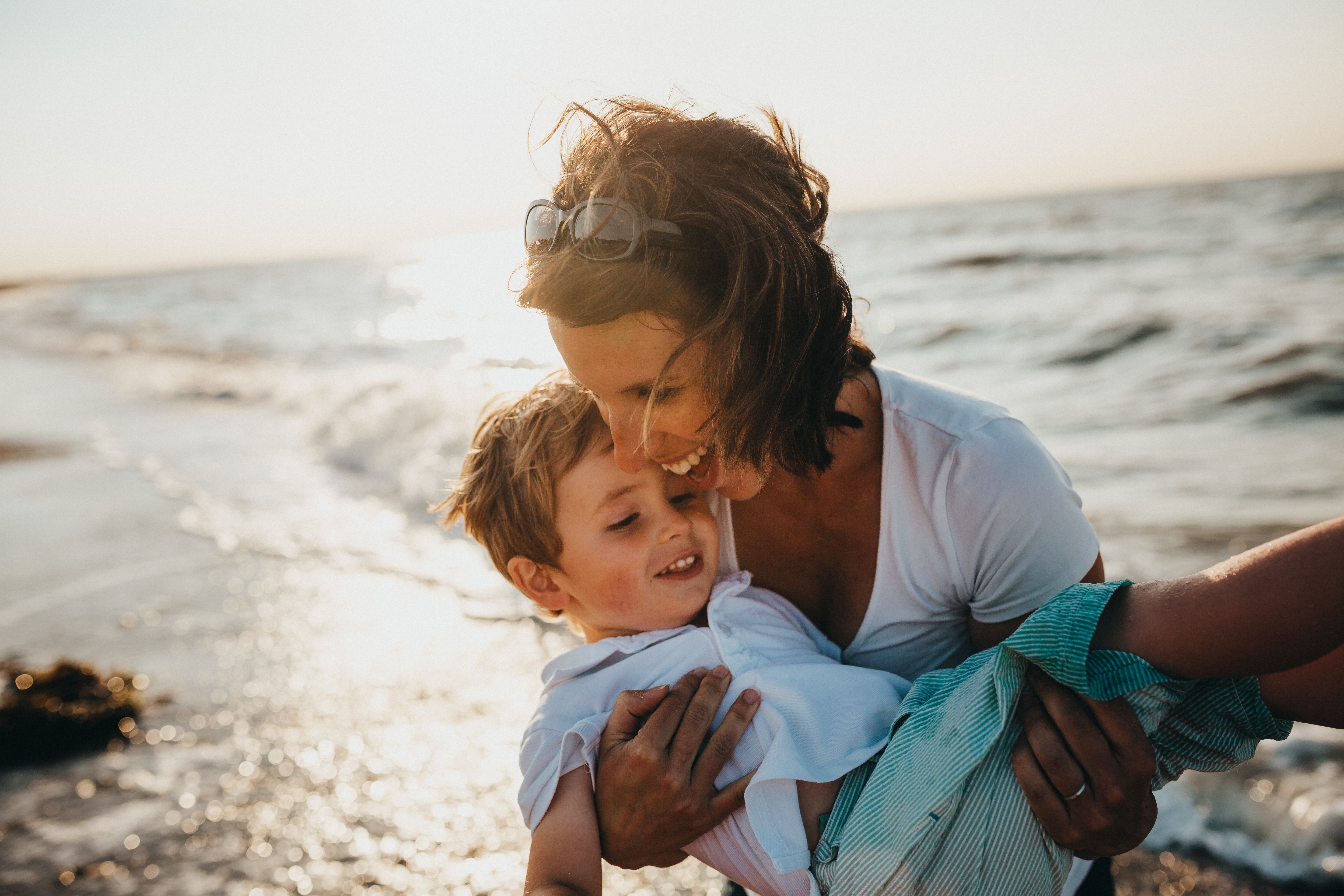 mom holding child on the beach 