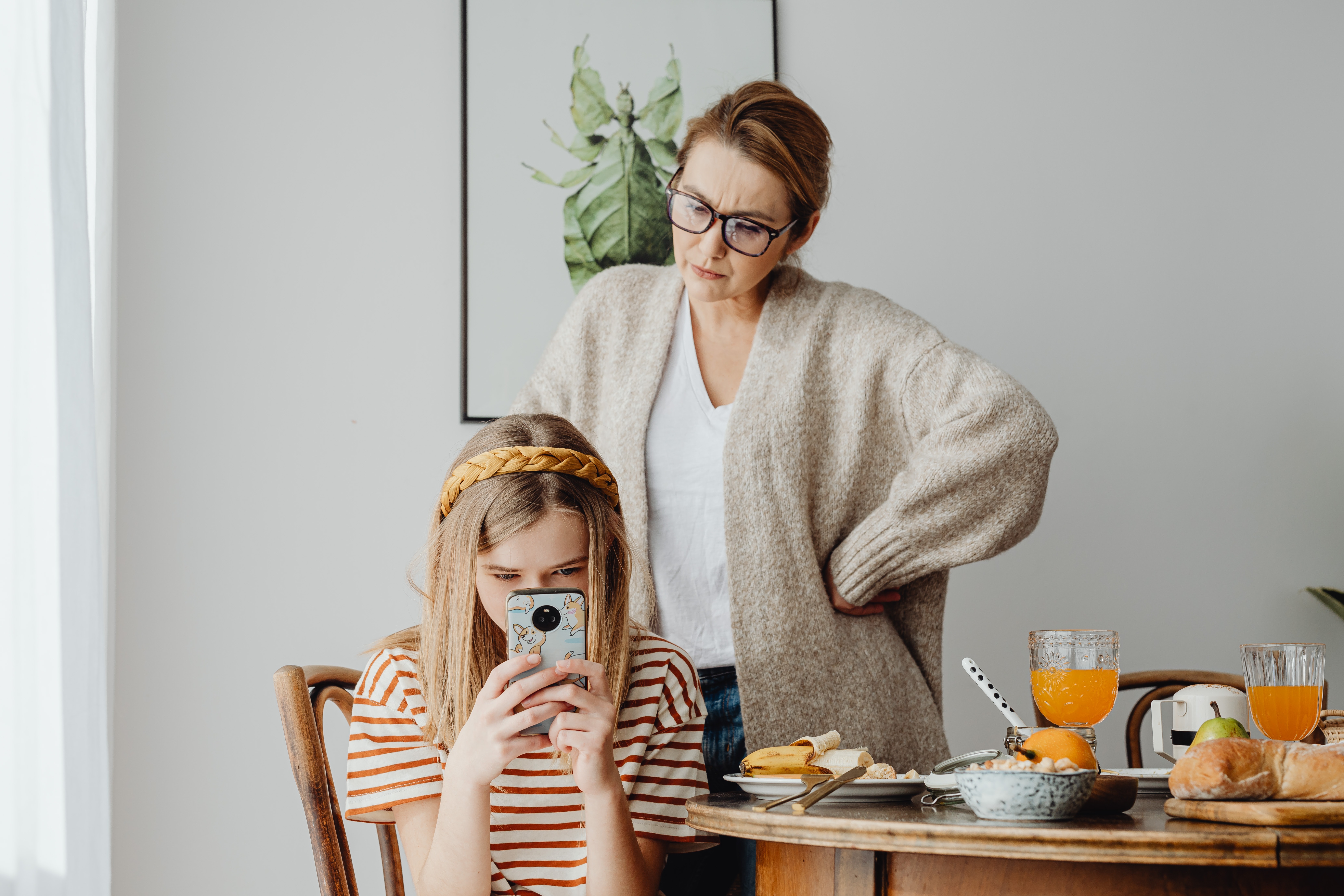 mère frustrée regardant un enfant utilisant un smartphone 