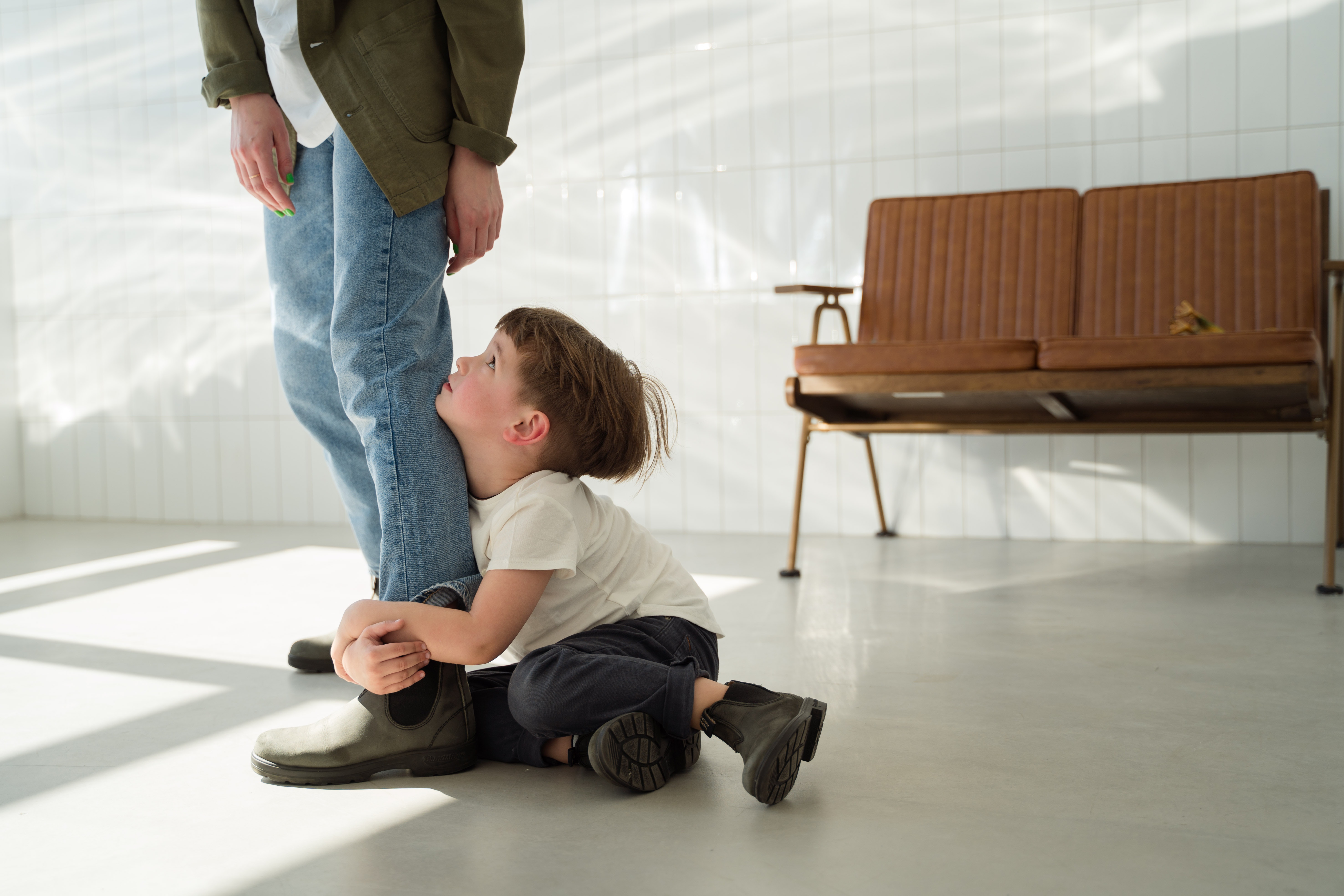 child wrapping arms around parent’s legs 