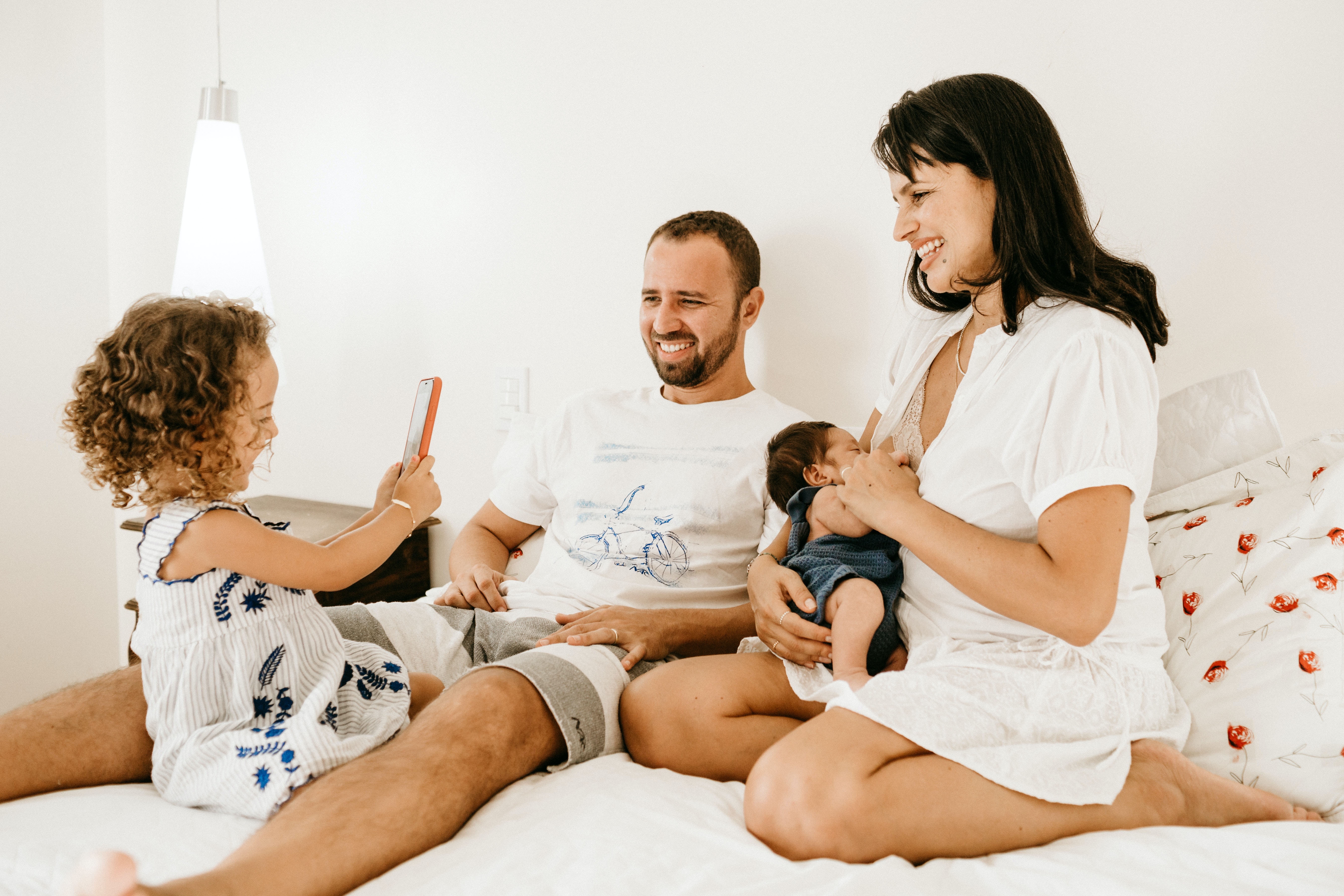 family of four sitting on a bed 