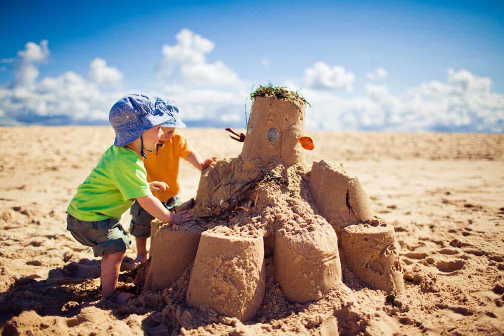 deux enfants construisant un château de sable 