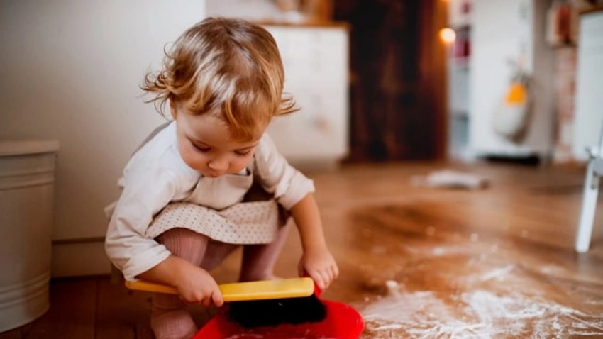 un tout-petit qui essuie une éclaboussure comme corvée 