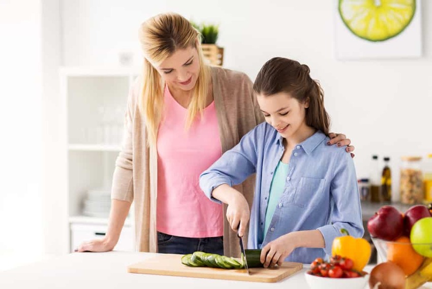 un adolescent qui prépare un repas en guise de corvée 