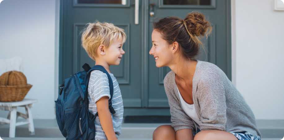 Mom watching her 6-year-old daughter walk to school with phone in hand