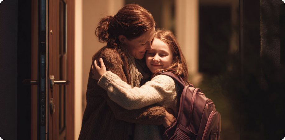 Mom watching phone while young child walks home with backpack